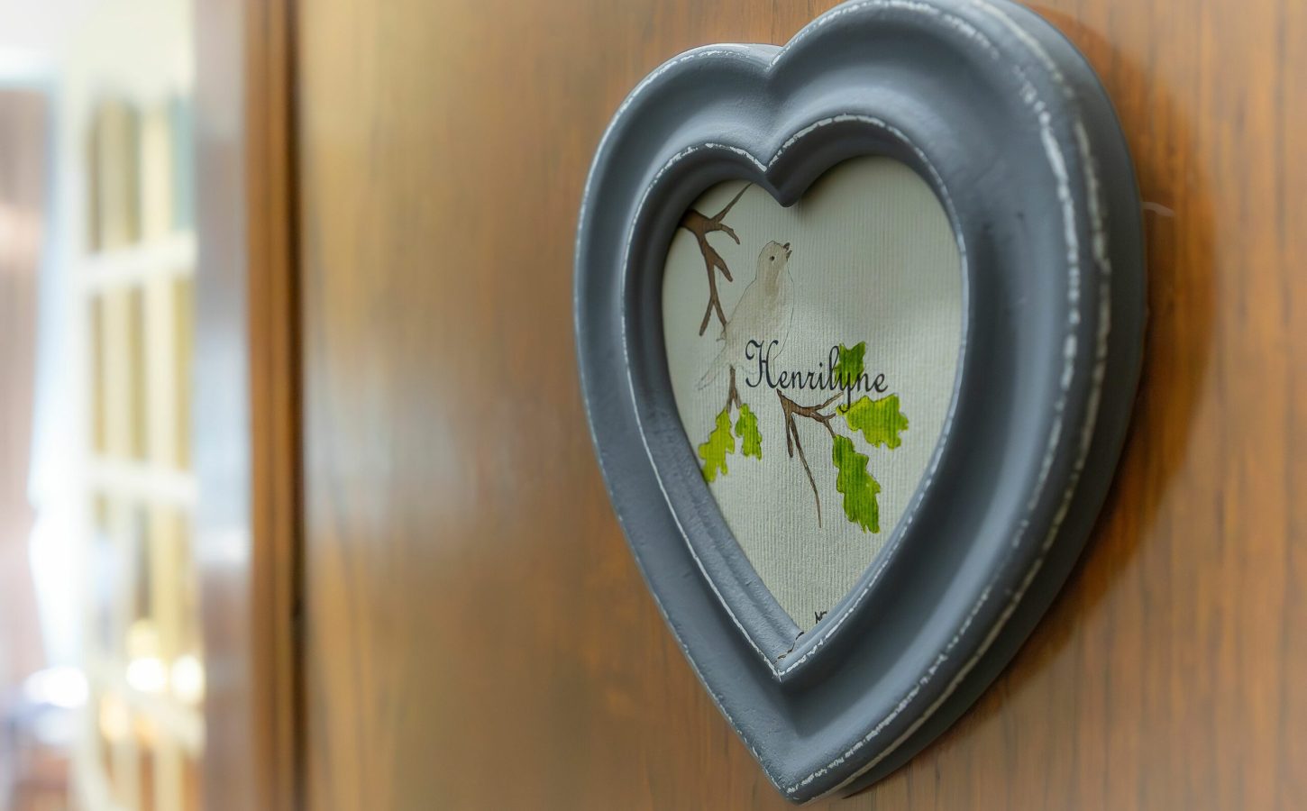 Plaque de porte en forme de cœur ornée d’un décor végétal, détail poétique qui signe l’identité des chambres du Clos Cathala